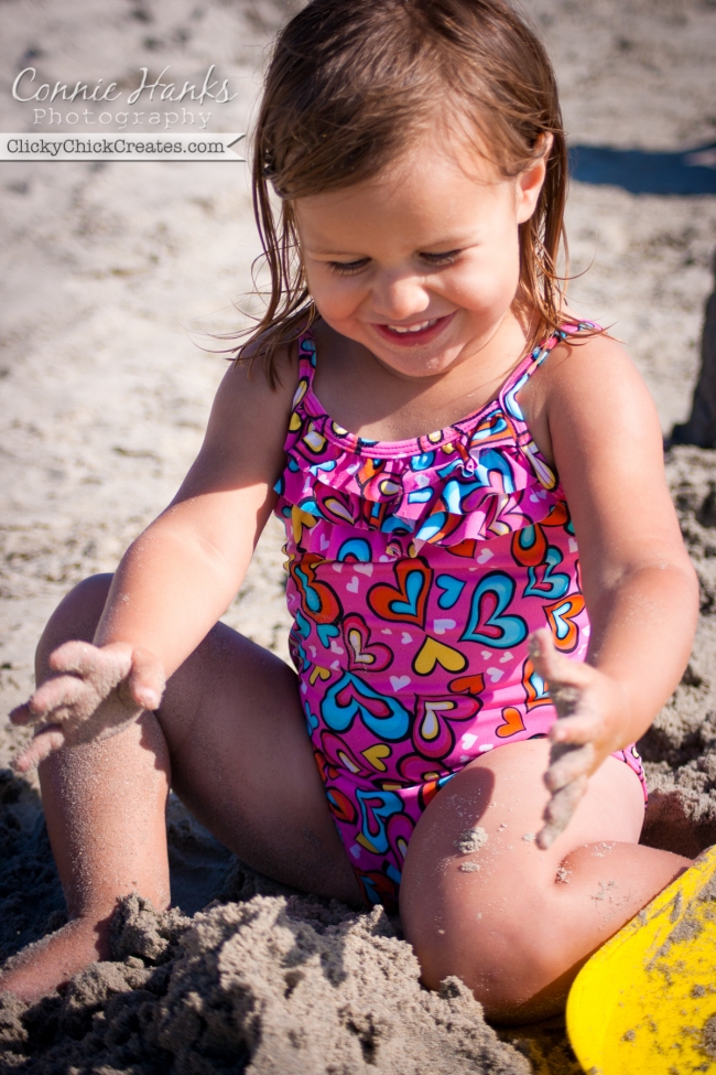 Connie Hanks Photography  //  ClickyChickCreates.com  //  baby girl enjoying building sand castles at beach on sunny day